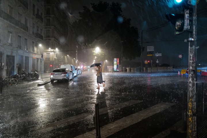 Una mujer cruza una calle durante una tormenta en el centro de Lyon. Foto: OLIVIER CHASSIGNOLE / AFP