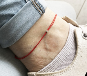 Significado de llevar una cinta roja en el tobillo izquierdo